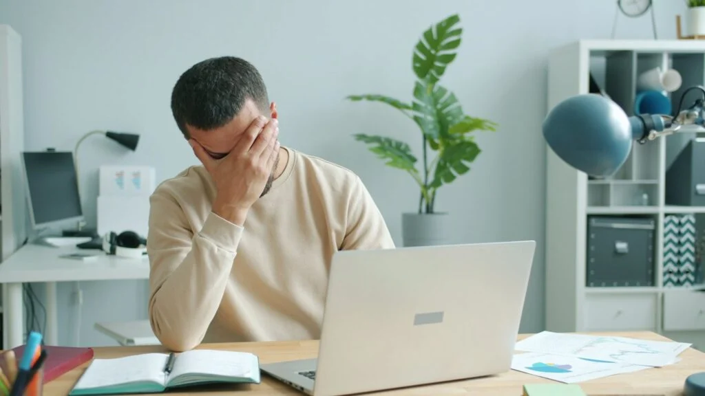 Mężczyzna przy laptopie przegląda porady w internecie